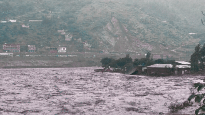 Local residents watch the Swat River overflow near Mingora after heavy pre‑monsoon rains on June 27 2025
